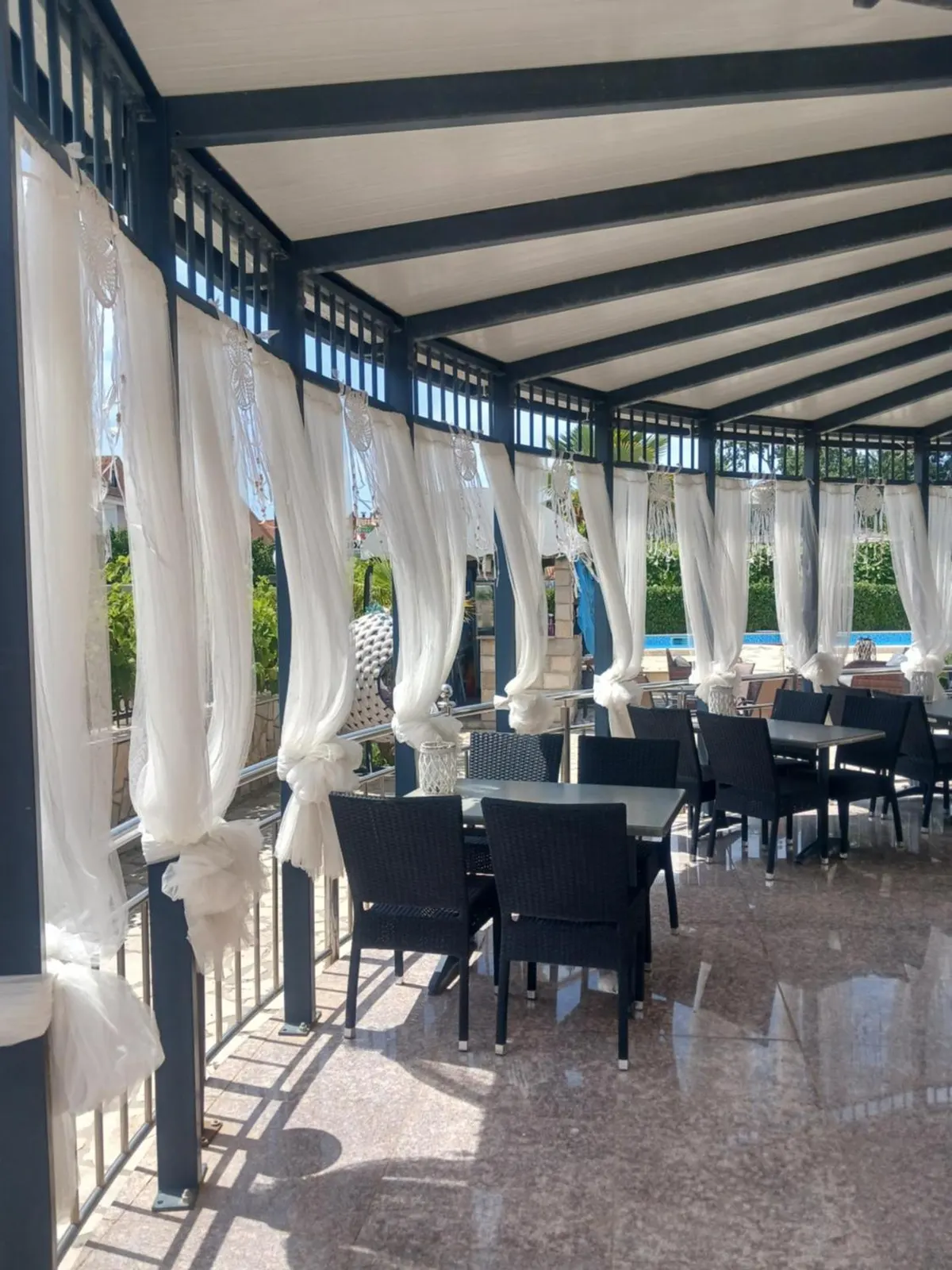 Covered dining terrace with prepared tables